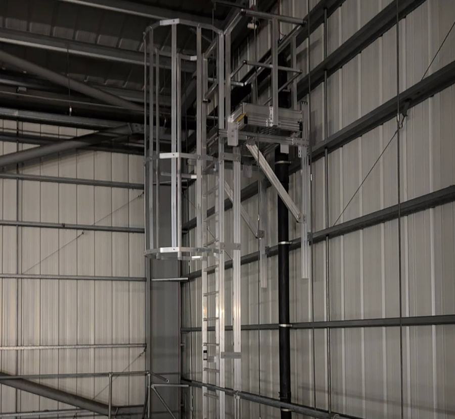 Aluminium caged ladder with a landing platform inside a cold store