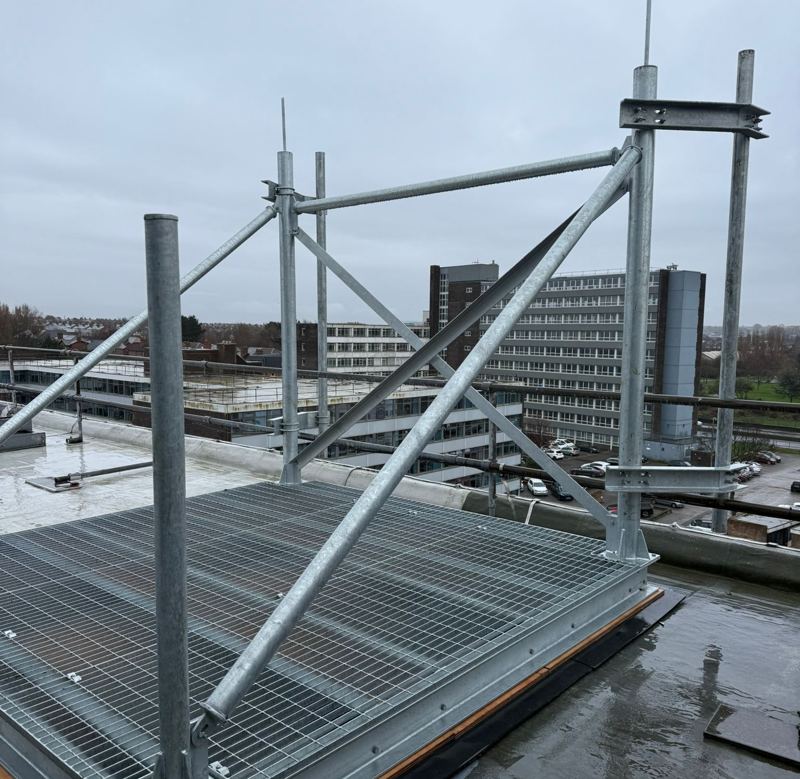 Galvanised steel antenna frame on a grated platform on a flat roof